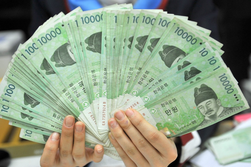 A bank employee displays South Korean won banknotes in Seoul. Photo: AFP