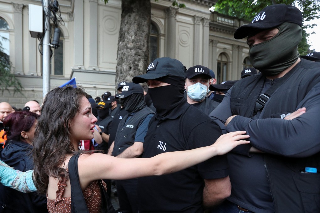 Demonstrators stand in front of law enforcement officers during a rally in Tbilisi, Georgia, on Tuesday. Photo: Reuters