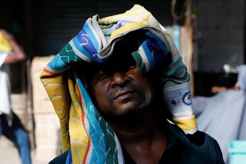 A man uses a towel to protect his head from the heat on a hot summer day in New Delhi, India. Photo: Reuters