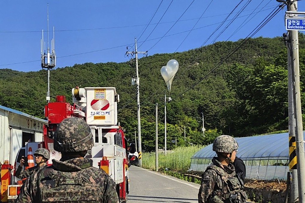 Balloons with garbage sent by North Korea, hang on electric wires as South Korean army soldiers stand guard in Muju. Photo: AP