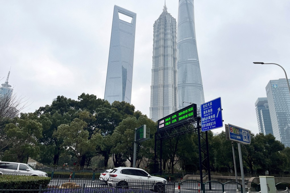 Cars travel past a display showing Shanghai and Shenzhen stock indexes near the Shanghai Tower and other skyscrapers at the Lujiazui financial district in Shanghai on February 5, 2024. Photo: Reuters