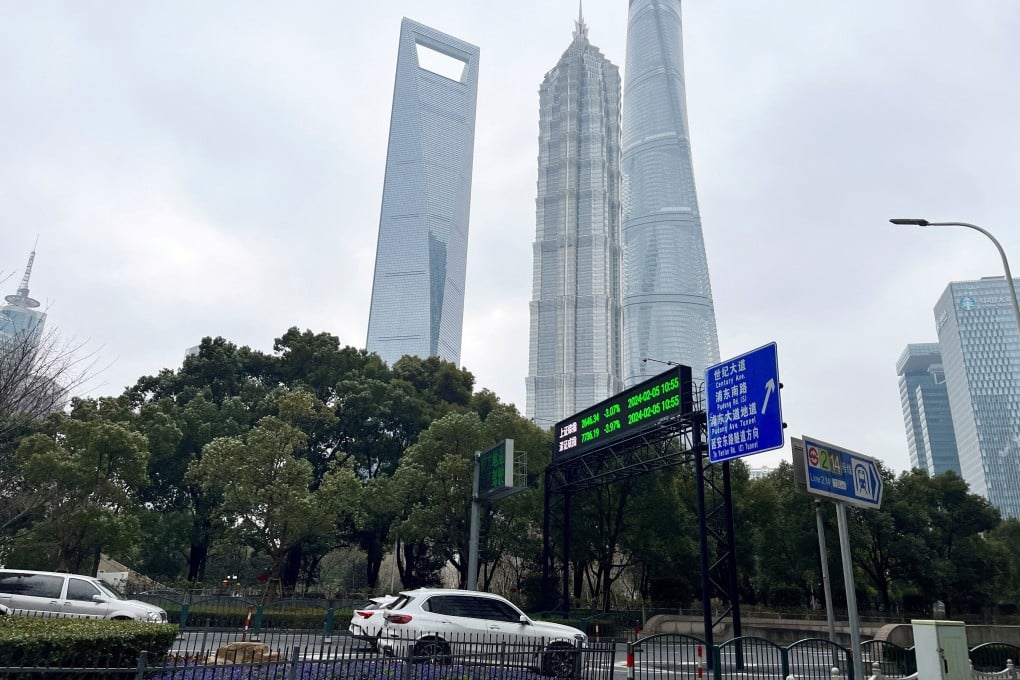 Cars travel past a display showing Shanghai and Shenzhen stock indexes near the Shanghai Tower and other skyscrapers at the Lujiazui financial district in Shanghai on February 5, 2024. Photo: Reuters