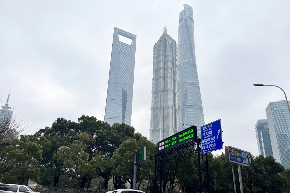 Cars travel past a display showing Shanghai and Shenzhen stock indexes near the Shanghai Tower and other skyscrapers at the Lujiazui financial district in Shanghai, China February 5, 2024. Photo: Reuters