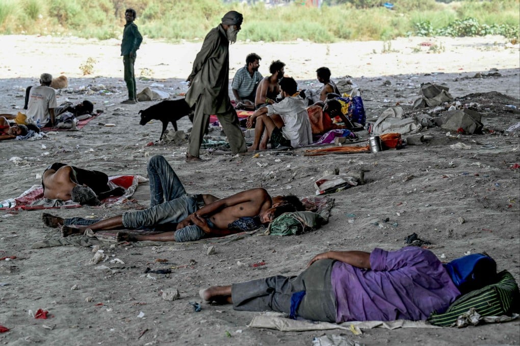 Homeless people are seen resting under a flyover on the banks of the Yamuna river in New Delhi to shield themselves from the sun on May 31. Photo: AFP
