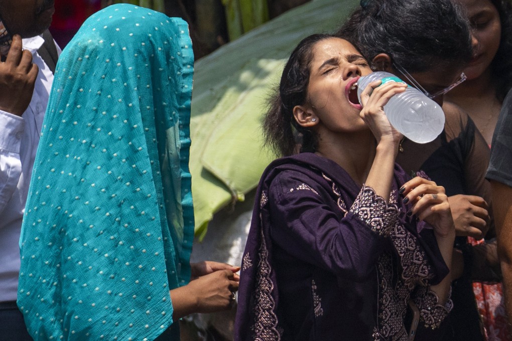 A woman drinks water as she waits for bus on a hot day in Mumbai late last month. Photo: AP