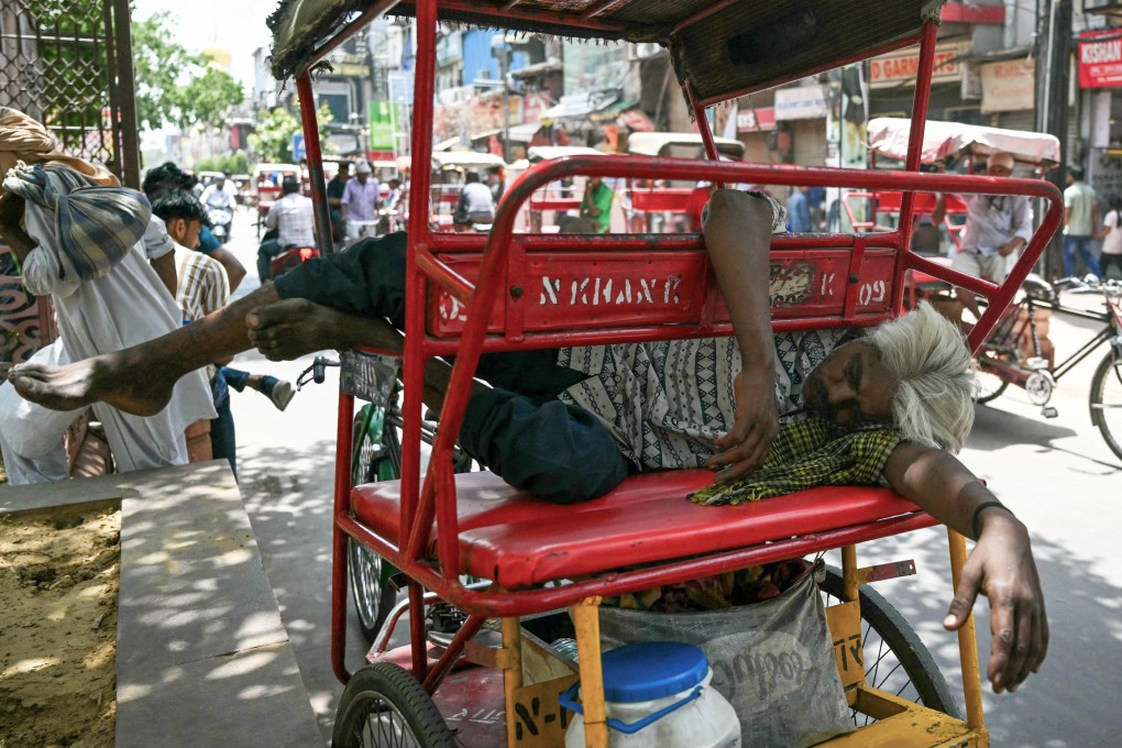A man sleeps on his rickshaw along a street on a hot summer day in New Delhi on May 31. Photo: AFP