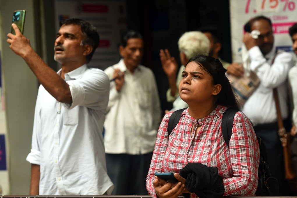 Stock market watchers monitor prices on an electronic board outside the Bombay Stock Exchange building in Mumbai on June 3. Stock prices recorded a high on the back of exit polls forecasting a massive victory for Modi’s party before plunging over the surprise election result. Photo: EPA-EFE