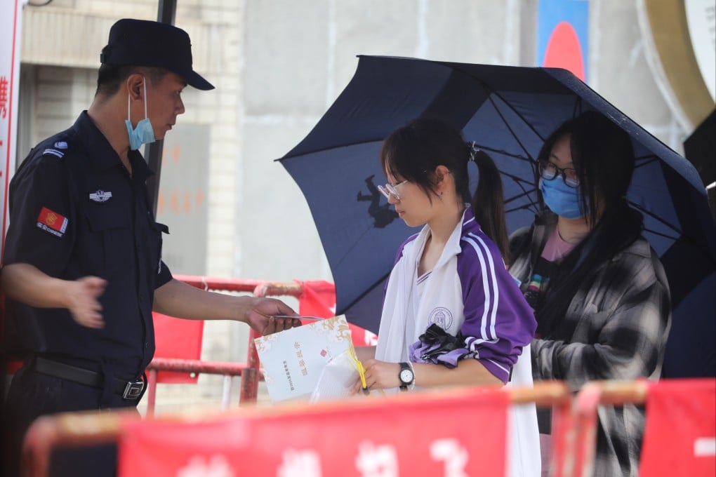 A security checks the ID and registration card of a student attending China’s annual national college entrance exam, also known as gaokao, on Friday, June 7. Photo: Simon Song
