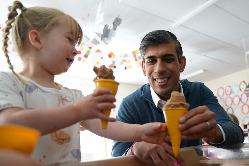 British Prime Minister Rishi Sunak speaks to a little girl during a visit to Imagination Childcare while on the campaign trail in Wiltshire on Friday. Photo: PA via dpa