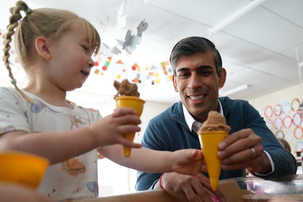 British Prime Minister Rishi Sunak speaks to a little girl during a visit to Imagination Childcare while on the campaign trail in Wiltshire on Friday. Photo: PA via dpa