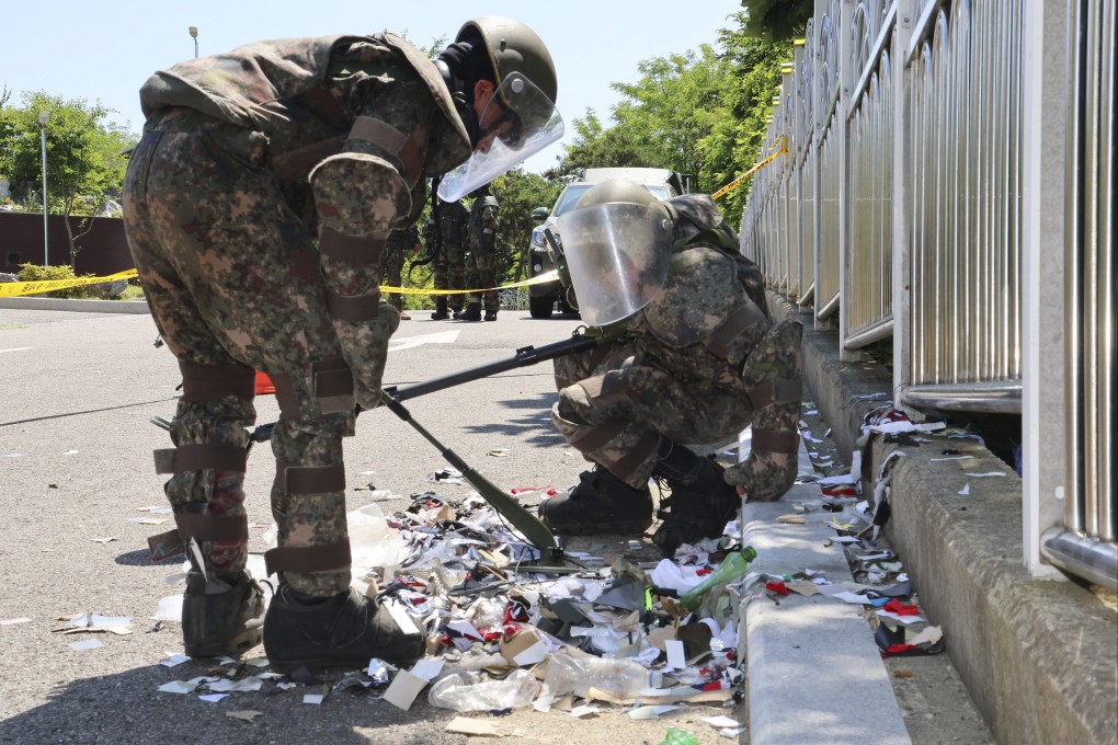 South Korean soldiers wearing protective gear check the trash from a balloon believed to have been sent by North Korea, in Incheon, South Korea, on June 2. Photo: Yonhap via AP