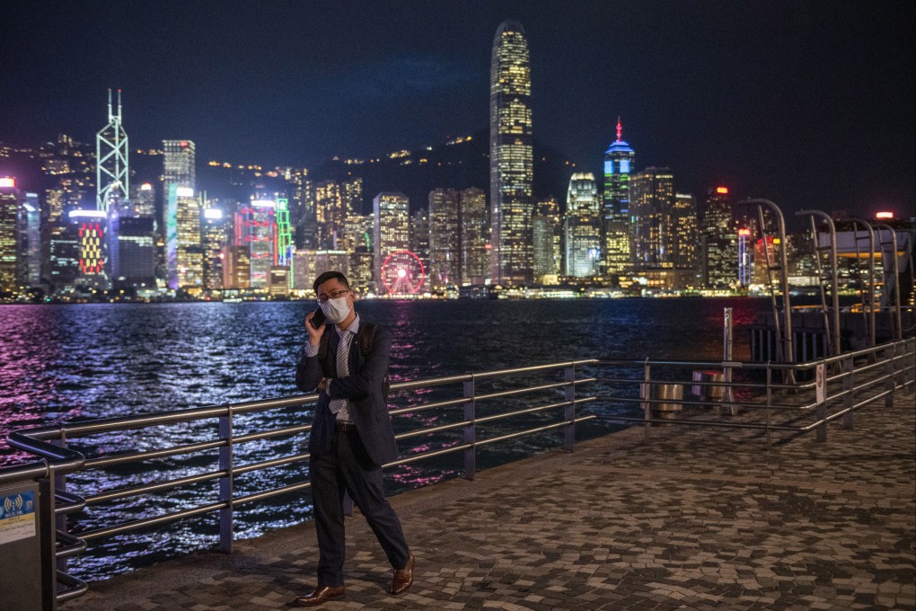 A pedestrian takes a phone call in front of Hong Kong’s skyline, with the city’s financial district right across the harbour, on October 19, 2022. Photo: AP