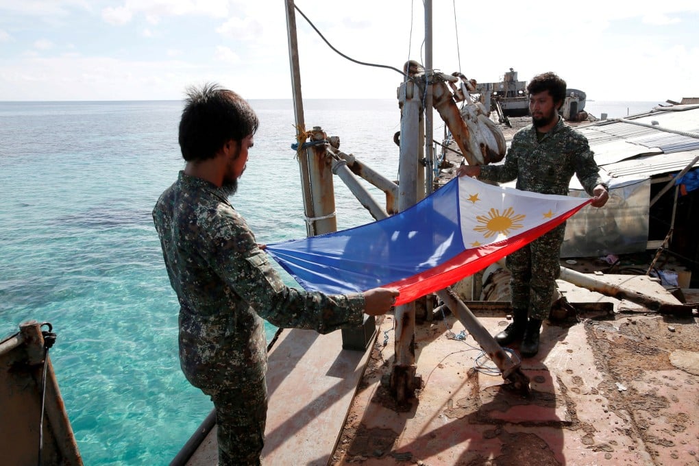 Philippine marines fold their national flag during a flag retreat at the BRP Sierra Madre, a marooned transport ship in the disputed Second Thomas Shoal. Photo: Reuters