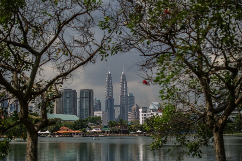 Malaysia’s landmark Petronas Twin Towers are seen between trees in Kuala Lumpur. Photo: AFP