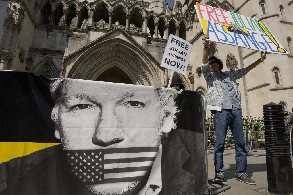 A protester stands outside the High Court in London A British court has ruled that WikiLeaks founder Julian Assange can appeal against an order that he be extradited to the US on espionage charges. Photo: AP