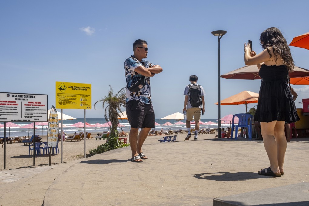 Foreign tourists take pictures on a beach in Seminyak last month. Bali deported dozens of badly behaved foreigners last year, but the crackdown has failed to deter some travellers. Photo: EPA-EFE