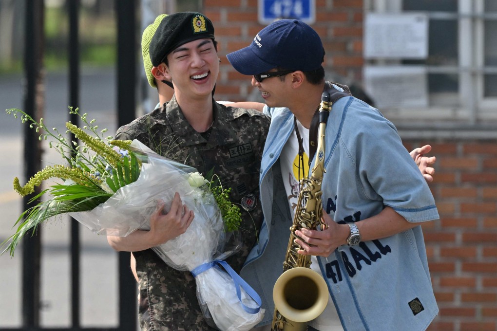 K-pop boy band BTS member Jin is greeted by fellow BTS member RM after being discharged from his mandatory military service outside a base in Yeoncheon on Wednesday. Photo: AFP