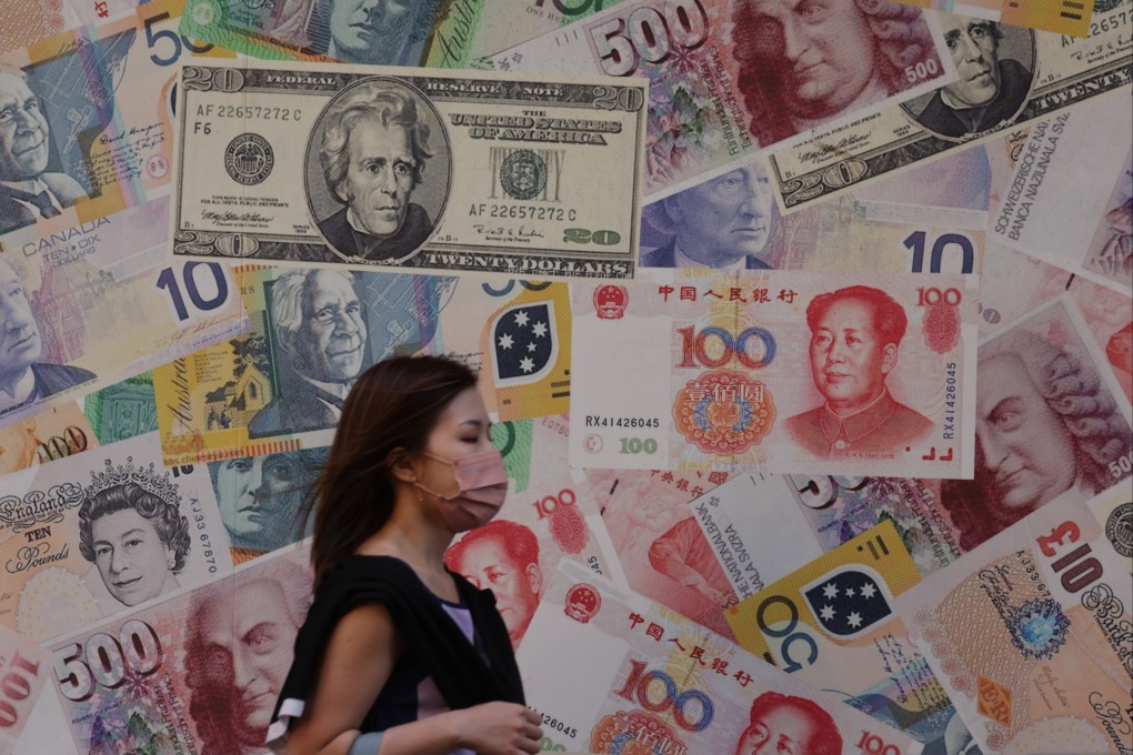 A pedestrian walks past a billboard displaying various currency notes outside a foreign exchange shop in Sheung Wan on 21 October 2022. Photo: Yik Yeung -man.