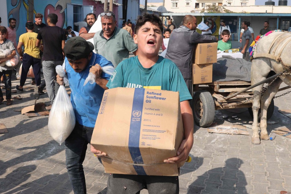 Palestinians collect food from a UN-run aid supply centre, distributing food to local Palestinians and people displaced. Photo: AFP