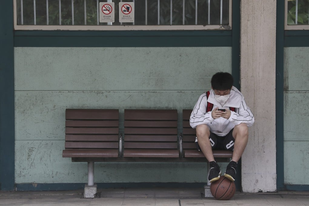 A student uses a mobile device at Kowloon Tong MTR station in 2020. Photo: Jonathan Wong