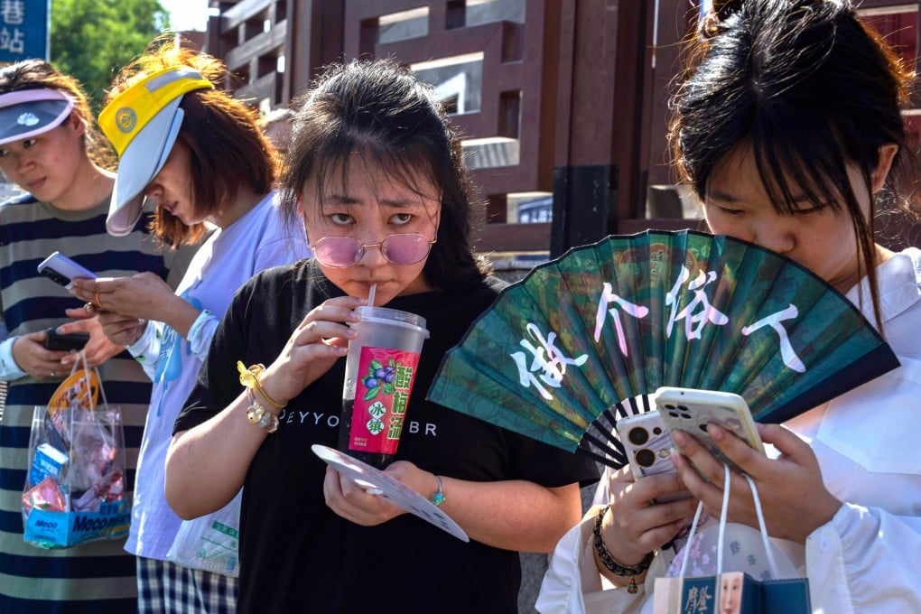 Chinese women use their smartphones on Wednesday in Beijing. Photo: AP