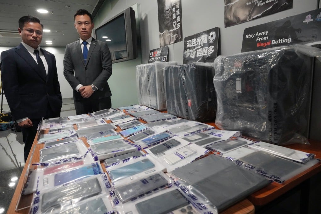(From left) Police Chief Inspector Wong Yu-Fai and Senior Inspector Wong Chun-hong with electronic devices and ledgers seized in a crackdown on illegal gambling. Photo: May Tse