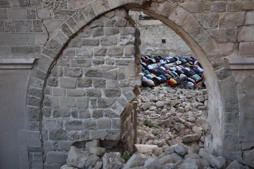 Palestinians perform the Eid al-Adha morning prayer amid rubble in Gaza City on Sunday. Photo: AFP