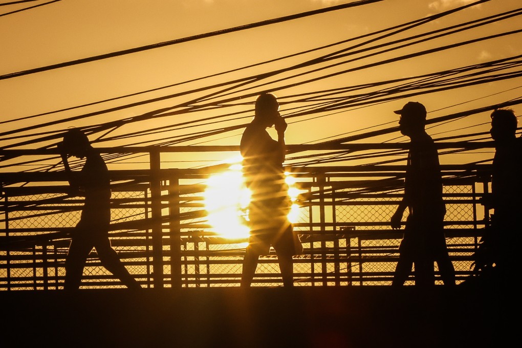 People walk through scorching heat in Quezon City during April’s intense heatwave, which officials have partly blamed for the Philippines’ current power crisis. Photo: Xinhua