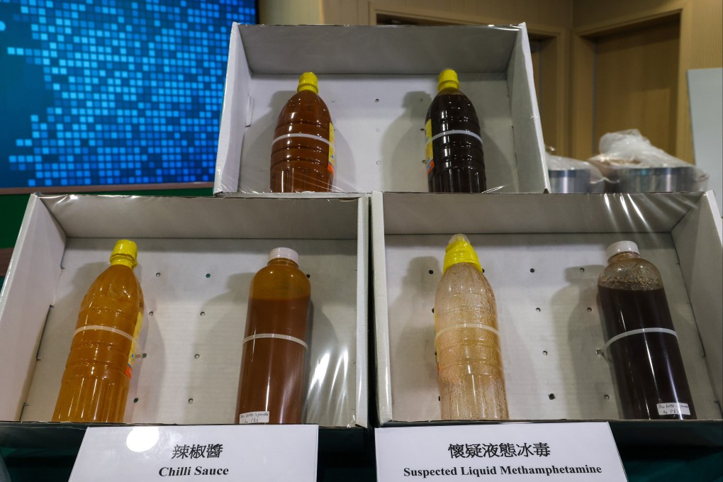 Customs officials display liquid methamphetatmine disguised as chilli sauce, seized in a raid on a Fanling warehouse. Photo: Jelly Tse