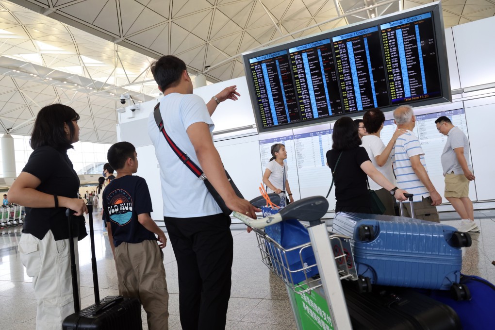 Travellers check a flight display screen at the departure hall at Hong Kong International Airport on Monday. Photo: Jelly Tse