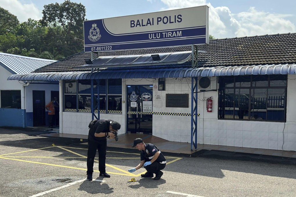 A police forensic team investigate outside a police station in southern Johor state that was stormed by a man with a machete on May 17. Photo :AP