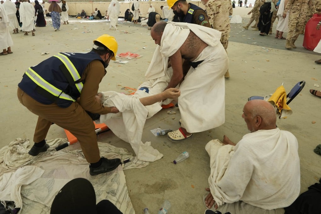 Paramedics carry a muslim pilgrim for a medical check after he fell down due to a heat stroke near Mecca, Saudi Arabia. Photo: AP