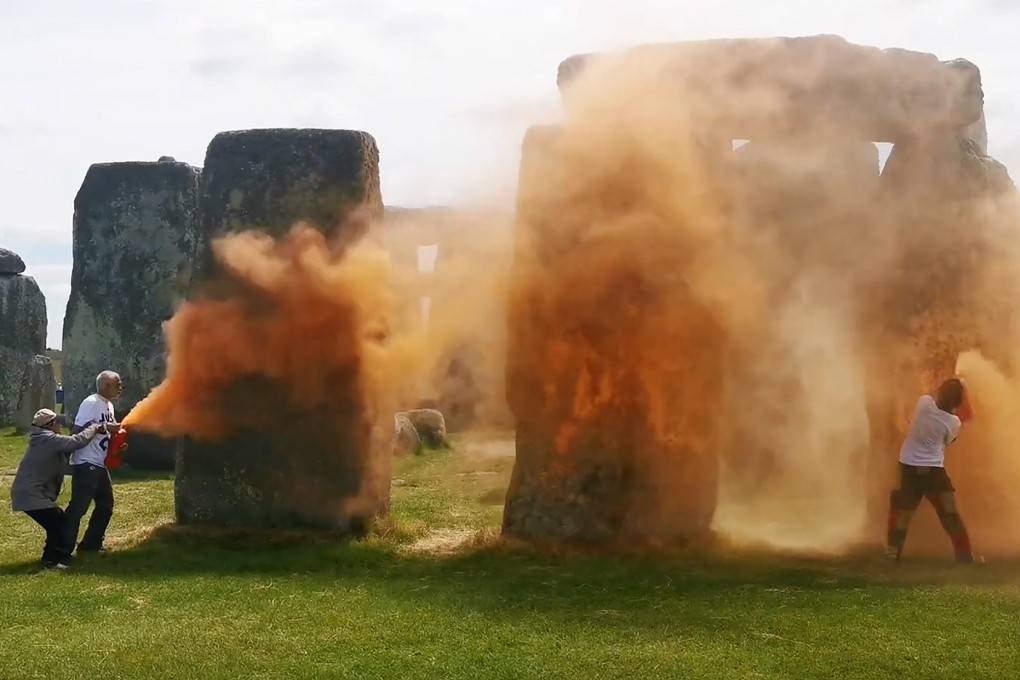 Activists spraying an orange substance at Stonehenge in Wiltshire, England, on Wednesday. Photo: Just Stop Oil via AFP