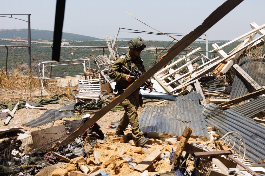 An Israeli soldier at the site of an Hezbollah anti-tank missile direct hit on a house near the Lebanon border in Moshav Shtula, northern Israel. Photo: Bloomberg