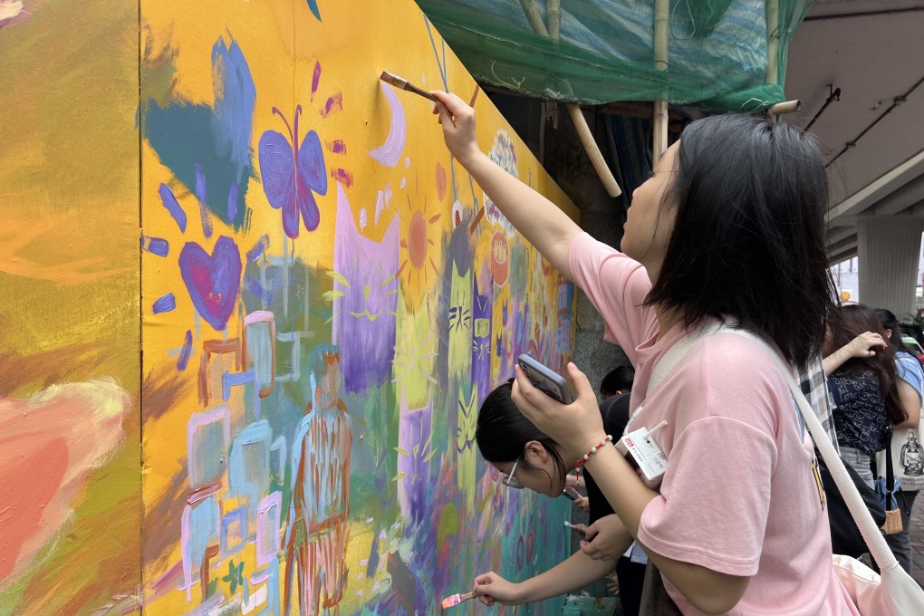 Mong Kok residents painting a mural on the hoarding of a construction site for a new building late last year in a community art project by the non-profit Art In Place. Photo: Art In Place Hong Kong