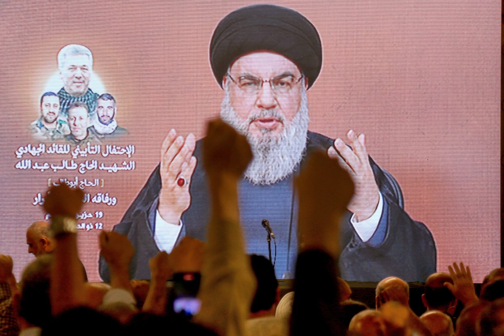 Supporters raise their fists as Lebanon’s Hezbollah leader Hassan Nasrallah gives a televised address on Wednesday. Photo: dpa