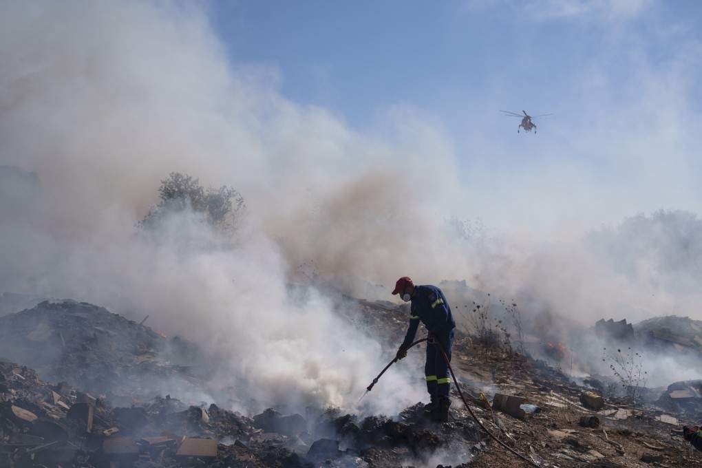 A firefighter tries to extinguish a fire burning in the Koropi suburb near Athens on June 19. Scores of Greek firefighters and water-bombing aircraft were trying to contain a large wildfire on the fringes of Athens that forced authorities to issue evacuation orders for two nearby settlements. Photo: AP