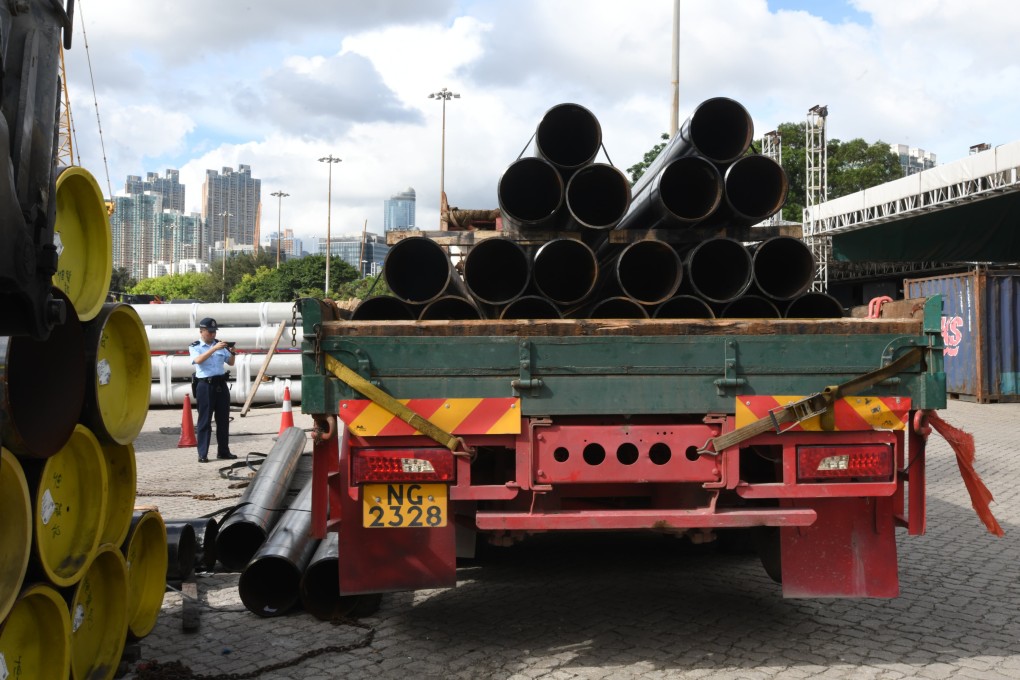 Police investigate the scene where a worker died after he was hit by steel pipes that fell off a truck in a loading yard. Photo: Handout