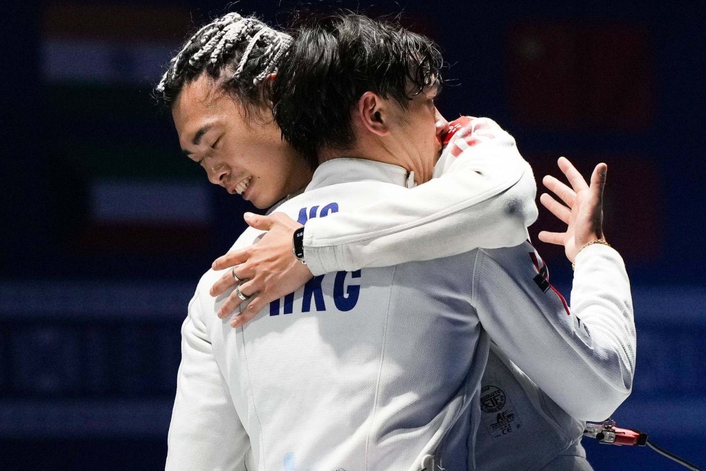 Hong Kong pair Cedric Ho (right) and Anson Ng embrace after the men’s épée final in Kuwait. Photo: FIE
