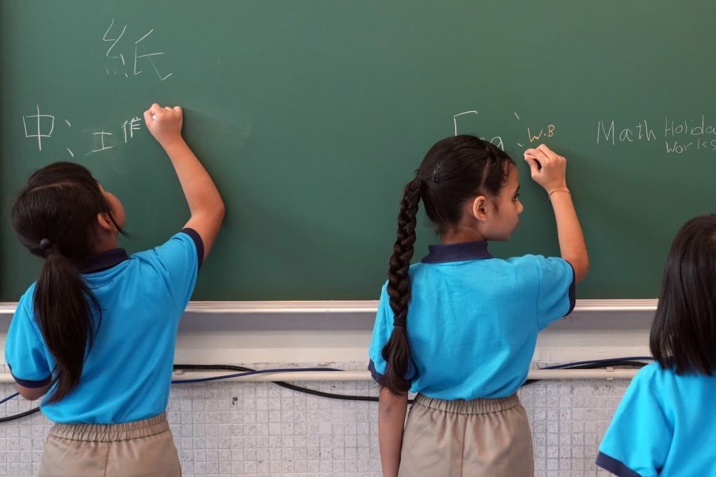 Students write on a chalk board at a primary school in Hong Kong’s Tsuen Wan district, on the first day of the school year on September 4, 2023. Photo: Sam Tsang