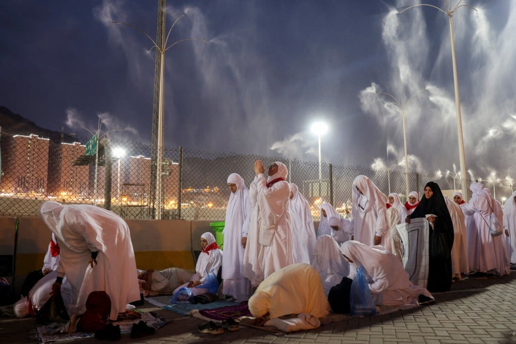 Muslim pilgrims pray as sprinklers spray water to cool them down in Mina, Saudi Arabia. Photo: Reuters