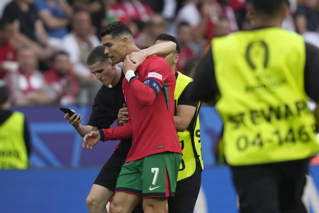 A pitch invader tries to take a selfie with Portugal’s Cristiano Ronaldo during a match between Turkey and Portugal at the Euro 2024 football tournament in Dortmund, Germany on Saturday. Photo: AP