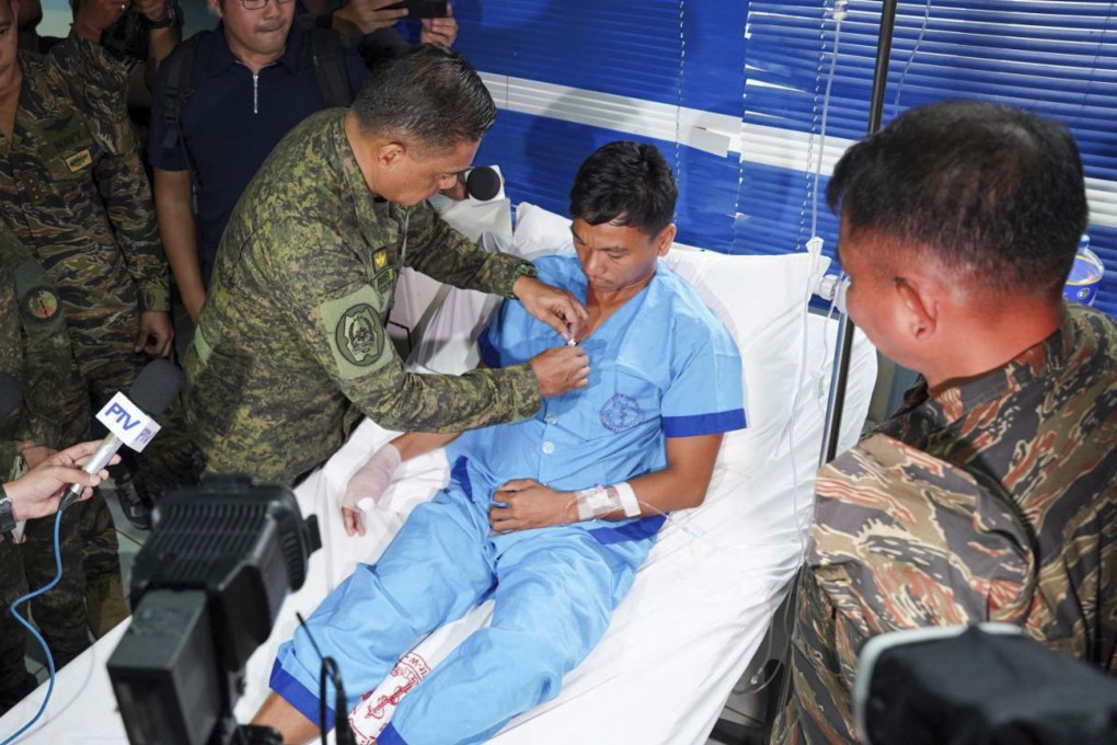 Philippine military chief General Romeo Brawner Jnr pins a medal on Jeffrey Facundo, who lost a thumb in the clash on June 17. Photo: Handout/Armed Forces of the Philippines/AP