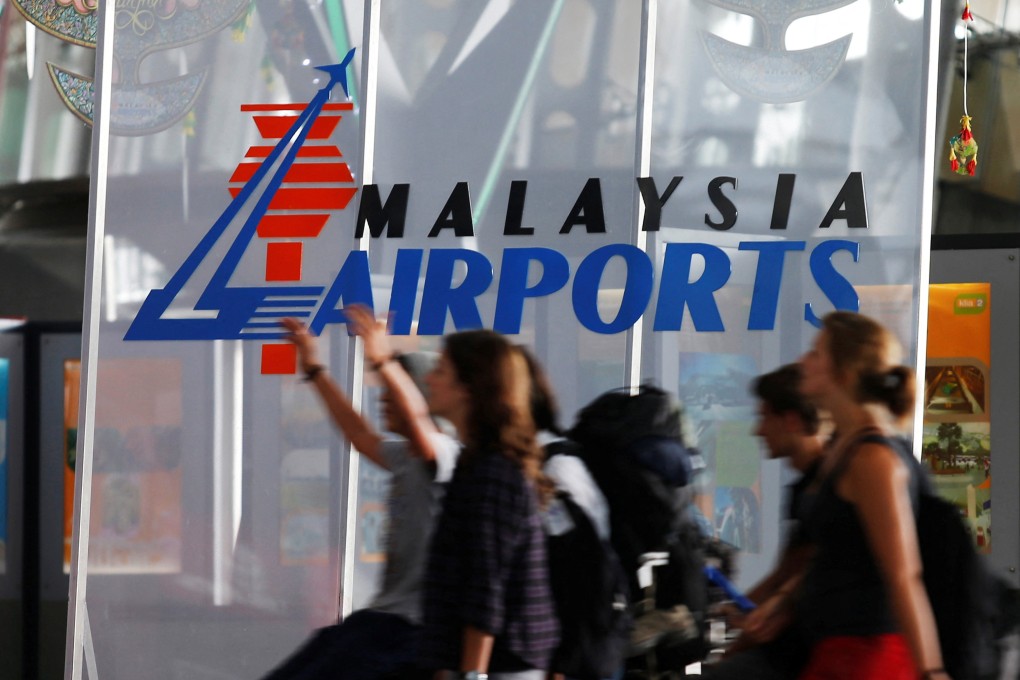 Travellers walk past a logo of Malaysia Airports Holdings Berhad at the departure hall of Kuala Lumpur International Airport. Photo: Reuters