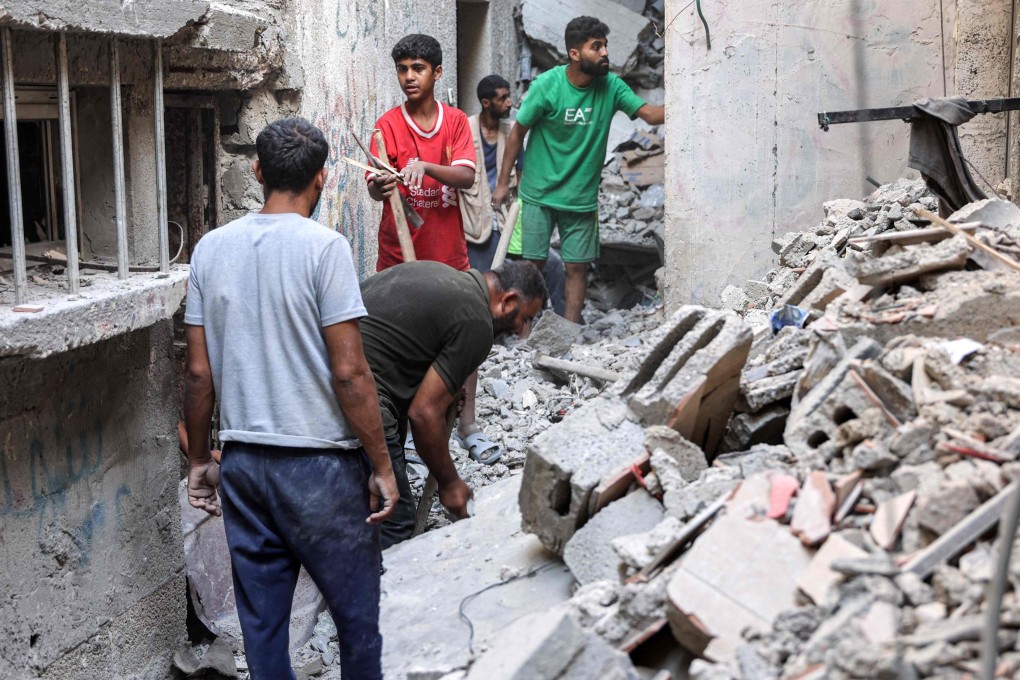 Men search through the rubble of the house of the sister of Ismail Haniyeh, the Doha-based political bureau chief of the Palestinian Islamist movement Hamas, after it was hit by Israeli bombardment on Tuesday. Photo: AFP
