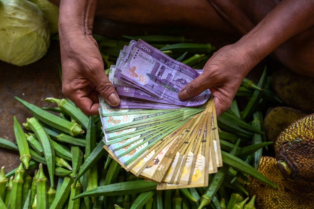 A vendor holds Sri Lankan banknotes at a market in Colombo. Photo: AFP