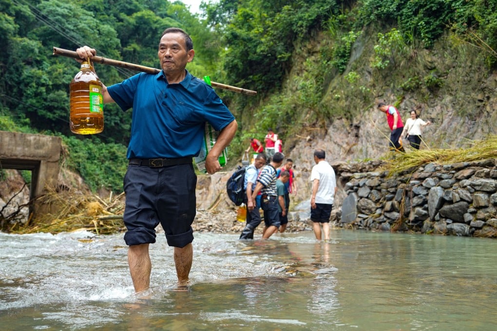 Volunteers from Yiwangxi in Hunan carry supplies to disaster victims. In 24 hours to 8am on Saturday, a record 395.6mm rainfall in the area caused landslides and isolated residents. Photo: Xinhua