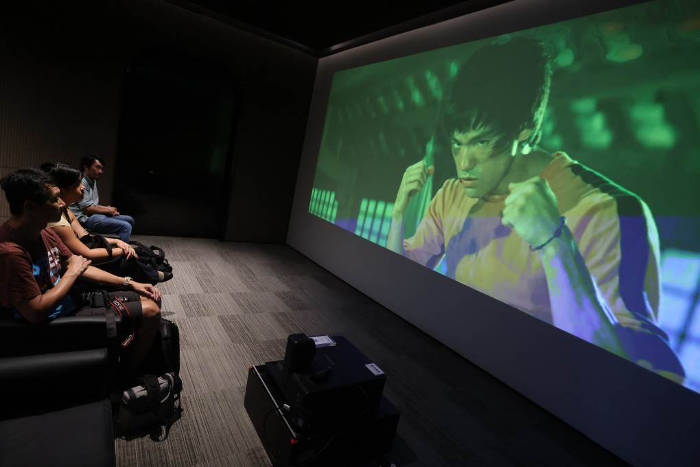 Visitors to a pop-up exhibition in Causeway Bay, Hong Kong, about Bruce Lee’s unfinished film Game of Death watch footage shot for the film. Photo: Jonathan Wong