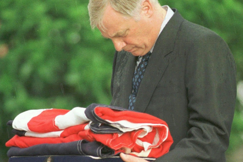 Governor Chris Patten bows his head as he stands in the rain to receive the British flag, which was lowered for the last time at Government House during a ceremony marking his departure on June 30, 1997, with the end of British rule over Hong Kong. Photo: AP