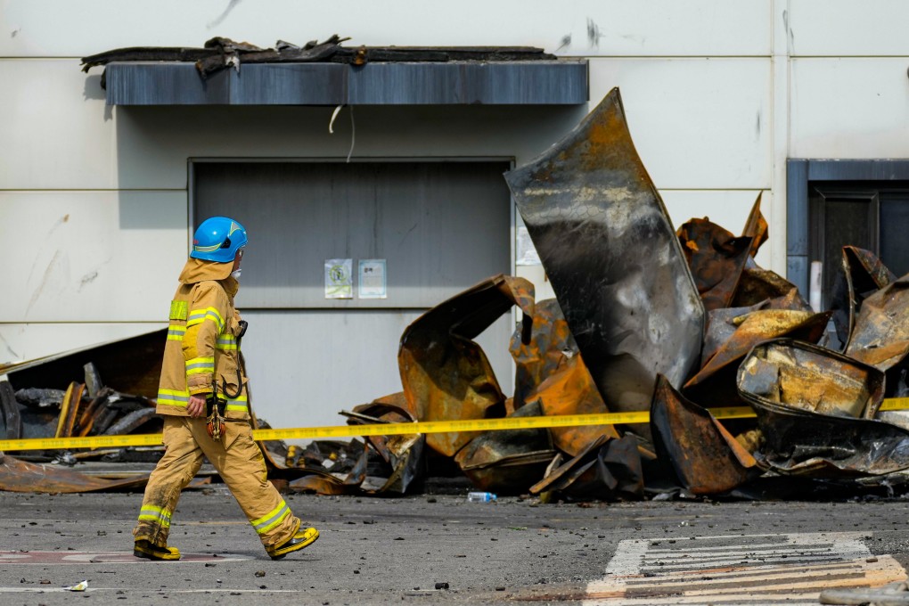 A firefighter walks near the debris at the site of a burnt lithium battery manufacturing factory in Hwaseong, South Korea, on June 25 after an explosion killed 22 people. Photo: AP